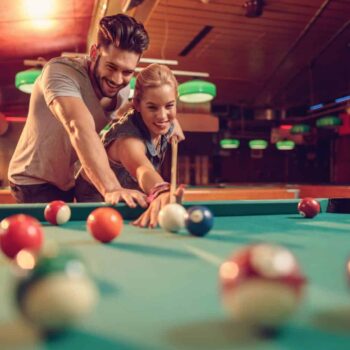 Young-happy-couple-enjoying-in-a-billiard-game-together-000083060405_Large